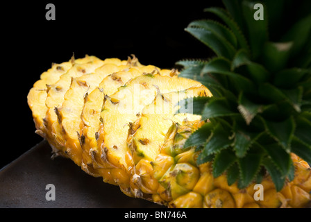 Ripe ananas dynamique sur une plaque noire en tranches Banque D'Images