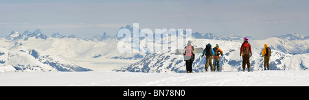 Les skieurs et planchistes de la randonnée le long de la crête de l'ouest de Mt. Alors que l'héliski Hawthorne près de Juneau, Alaska Banque D'Images