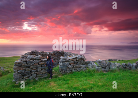 Un ciel coloré au coucher du soleil, et vieilles pierres à l'abri l'île Runde sur l'Atlantique, côte ouest de la Norvège. Banque D'Images