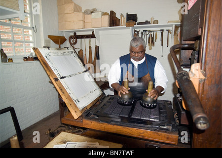 Un homme de métier, type d'encres pour reproduire un jour sur un journal de la presse à main à l'imprimerie dans la région de Colonial Williamsburg, Virginia, USA. Banque D'Images