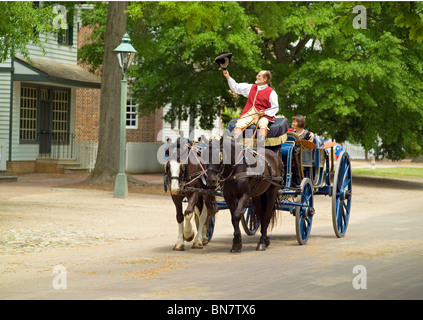 Les touristes profiter d'une balade en calèche à travers les rues de la ville coloniale de Williamsburg, au xviiie siècle un salon-attraction historique en Virginie, aux États-Unis. Banque D'Images