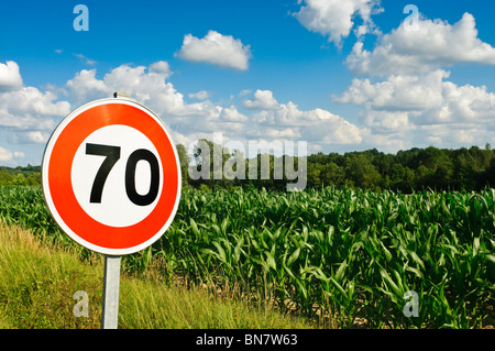 Limitation de vitesse 70 km/h signe / terre agricole avec de plus en plus de maïs - Maïs doux - Indre-et-Loire, France. Banque D'Images