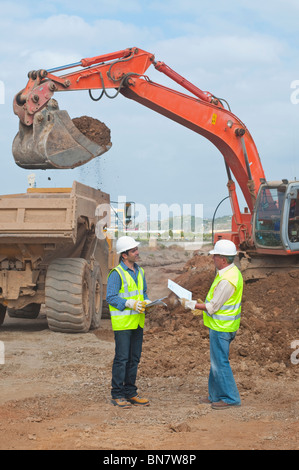 Hispanic construction workers talking on construction site Banque D'Images