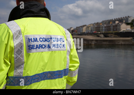 HM, le personnel de recherche et sauvetage de la Garde côtière portant veste hivis regarder près de la mer au Royaume-Uni Banque D'Images