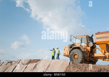 Les travailleurs de la construction dans la zone hispanique avec dump truck Banque D'Images