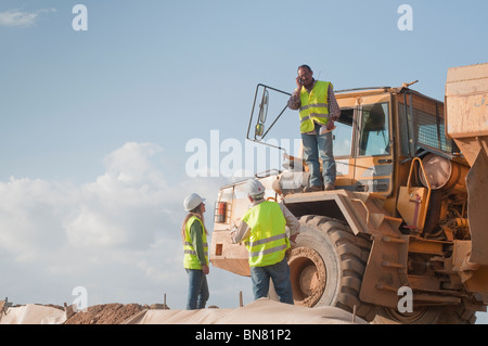 Les travailleurs de la construction d'origine hispanique près de dump truck Banque D'Images