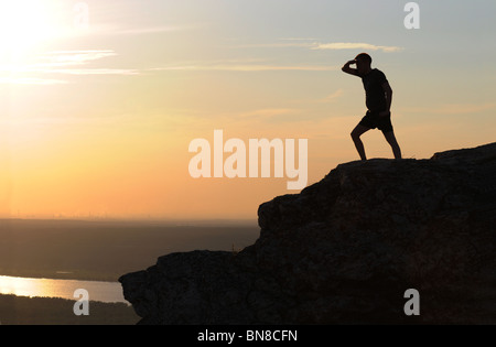 Silhouette d'un homme sur le point le plus élevé de montagnes Zhiguli dans Parc National Russe 'Samara Luka'. Banque D'Images
