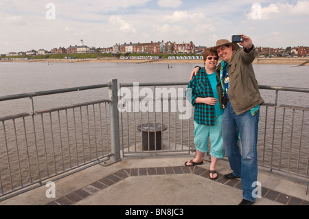 Un couple se photographier sur la jetée à Southwold, Suffolk , Bretagne , France Banque D'Images