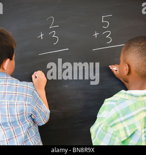 La résolution de problèmes de mathématiques les garçons on blackboard Banque D'Images