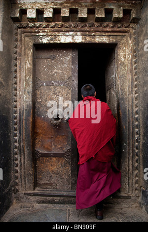 Moine dans une porte à monastère de Sera à Lhassa, Tibet Banque D'Images