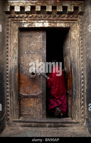 Moine dans une porte à monastère de Sera à Lhassa, Tibet Banque D'Images