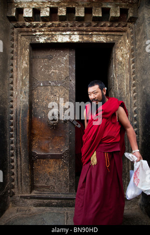 Moine dans une porte à monastère de Sera à Lhassa, Tibet Banque D'Images