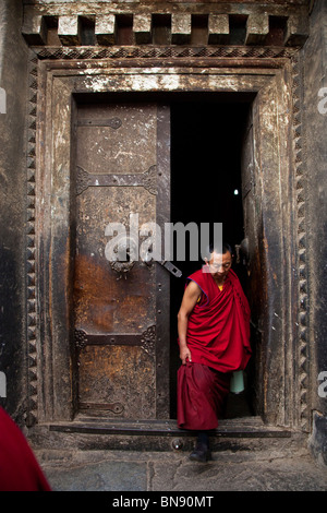 Moine dans une porte à monastère de Sera à Lhassa, Tibet Banque D'Images