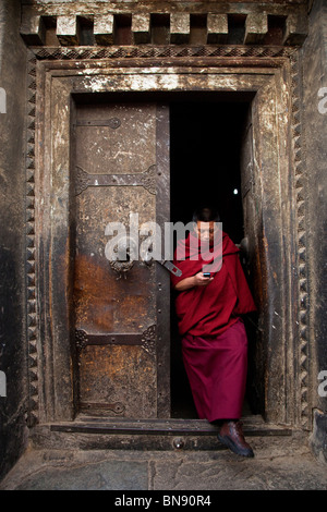 Moine dans une porte à monastère de Sera à Lhassa, Tibet Banque D'Images