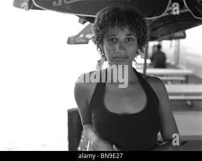 Mixed Race woman under umbrella in cafe Banque D'Images