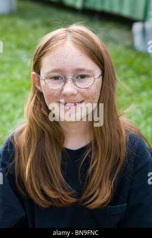 Portrait d'une jeune fille aux cheveux rouges de rousseur face à un marché de fermiers dans la petite ville de montagne de Salida, Colorado, USA Banque D'Images