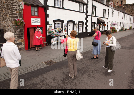 Pays de Galles, Gwynedd, Conway, touristes photographiant femme en costume gallois à l'extérieur de la Grande-Bretagne est plus petite maison Banque D'Images