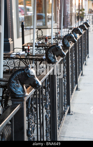 Clôture en fer forgé noir avec têtes de cheval au Harry's Seafood Bar and Grille sur la place au centre-ville d'Ocala, Floride Banque D'Images