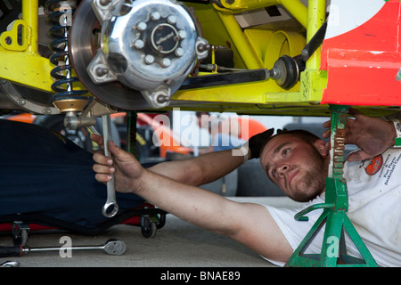 Woodstock, New Hampshire - un mécanicien travaille sur une voiture dans les stands pendant les courses de voitures à White Mountain Motorsports Park. Banque D'Images