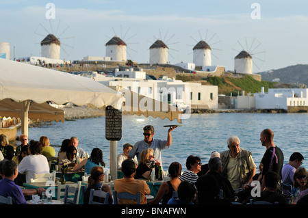 Mykonos. La Grèce. Le Kastro / Little Venice bar en bord de mer et les moulins à vent à l'arrière-plan. Banque D'Images