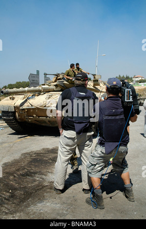 TV news crew le port de gilet pare-balles filmer les troupes israéliennes à la frontière nord d'Israël au Liban Banque D'Images