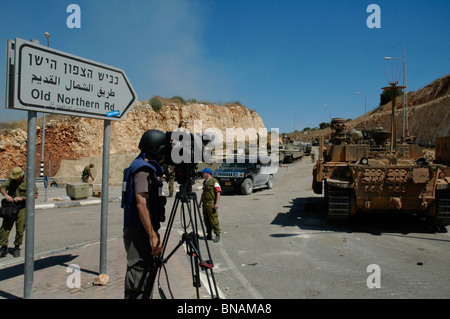TV news crew le port de gilet pare-balles filmer les troupes israéliennes à la frontière nord d'Israël au Liban Banque D'Images