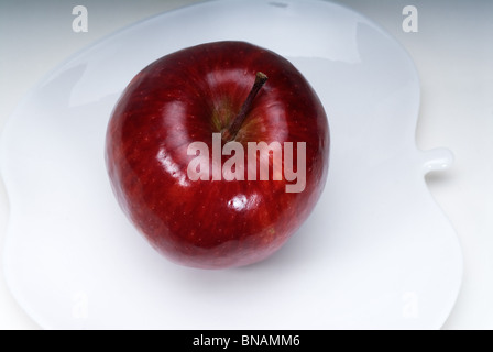 Pomme rouge sur un plat en forme de pomme isolated over white Banque D'Images