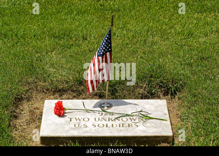 Un drapeau américain et une fleur honneur les tombes de deux inconnus des soldats américains de la guerre civile dans le Cimetière National d'Yorktown de Yorktown, en Virginie, USA. Banque D'Images