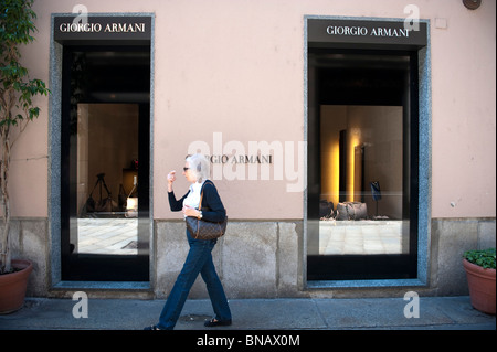 Une femme marche en avant du magasin Armani Milan Italie Banque D'Images