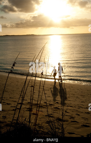 Couple on beach at sunset Banque D'Images