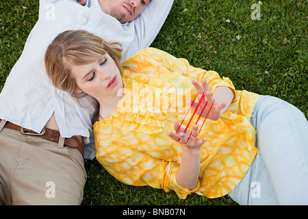 Young couple outdoors, woman Playing with string Banque D'Images