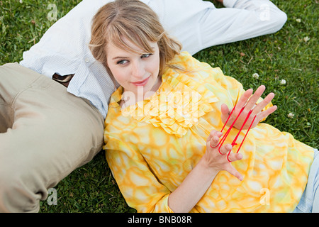 Young couple outdoors, woman Playing with string Banque D'Images