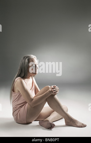 Senior woman sitting on floor Banque D'Images