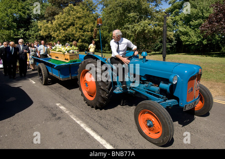 Un millésime 1960 tracteur Fordson Dexta tire le cercueil dans un village en porcession funéraire Falmer, Sussex, Angleterre, Royaume-Uni. Banque D'Images