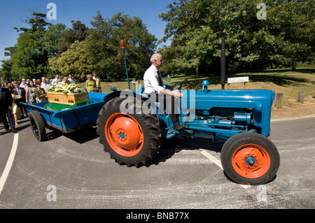 Un millésime 1960 tracteur Fordson Dexta tire le cercueil dans un village en porcession funéraire Falmer, Sussex, Angleterre, Royaume-Uni. Banque D'Images