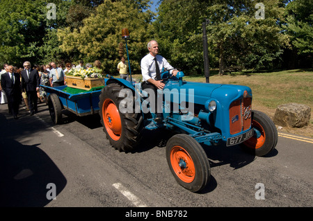 Un millésime 1960 tracteur Fordson Dexta tire le cercueil dans un village procession funéraire à Brighton and Hove, Sussex, Angleterre, Royaume-Uni. Banque D'Images