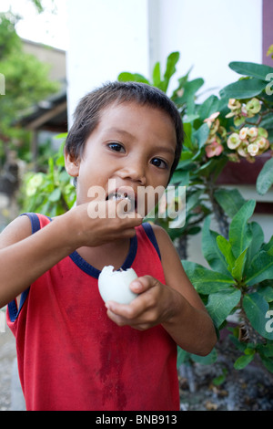 Un enfant philippin bénéficie d''un balut, ou cuit oeuf canard fécondé, à Mindoro oriental, Philippines. Banque D'Images