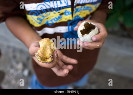 Un garçon affiche le jaune d'un balut, ou cuit oeuf canard fécondé, tout en appréciant les mets de choix dans les Philippines. Banque D'Images