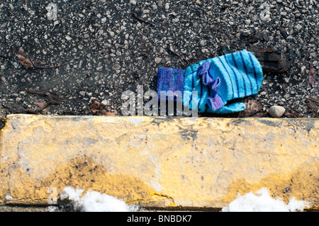 La perte d'un moufle fixe par le côté de la route sur une froide journée d'hiver. Banque D'Images