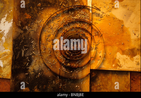 Spirale rouillée sur une surface endommagée avec des débris dispersés capturés par le haut Banque D'Images