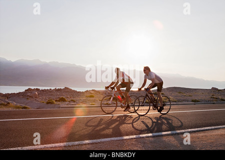 Les cyclistes sur route de campagne par la mer Banque D'Images