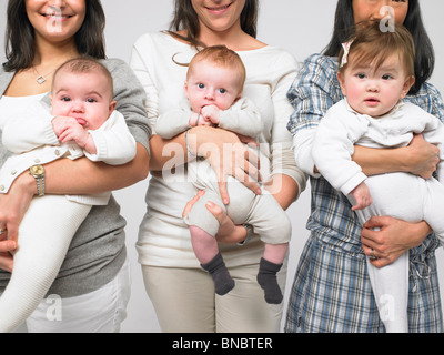 Les bébés dans les bras des mères Banque D'Images