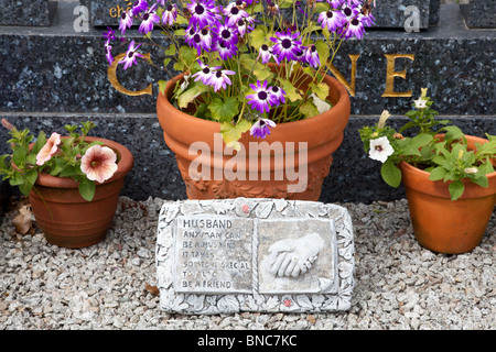 Fleurs et plaque avec message personnel en face de pierre tombale, Co Galway, Irlande Banque D'Images