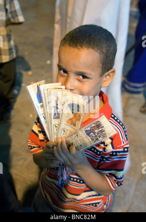 Enfant égyptien; un jeune garçon vendant des cadeaux aux touristes occidentaux dans les rues d'Assouan la nuit, Haute-Egypte Afrique - exemple de style de vie égyptien Banque D'Images