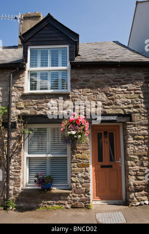 Rangée de cottages pittoresques mitoyennes avec paniers suspendus à l'extérieur à Hay-on-Wye Powys Pays de Galles UK Banque D'Images