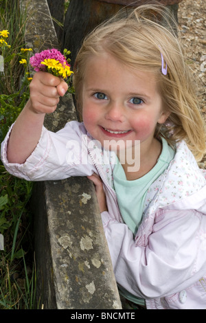 Little girl holding a bouquet de fleurs sauvages Banque D'Images