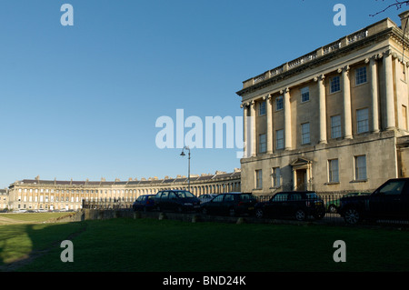 Colonnes d'inspiration classique Royal Crescent à Bath dans la matinée avec un ciel bleu et de voitures stationnées le long de la rue. Banque D'Images