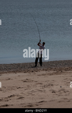 La pêche du bar de la plage, dans le Nord du Pays de Galles, Royaume-Uni. Banque D'Images