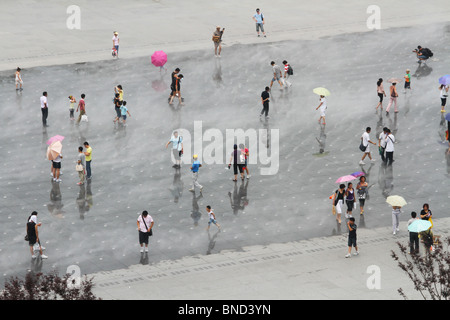 Les gens dans la brume Fontaine d'eau. 2010 Shanghai World Expo Park, Pudong, Shanghai, Chine. World's Fair. Banque D'Images