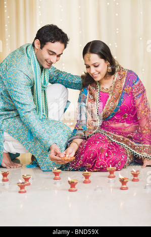 Couple decorating lampes à huile au festival du Diwali Banque D'Images